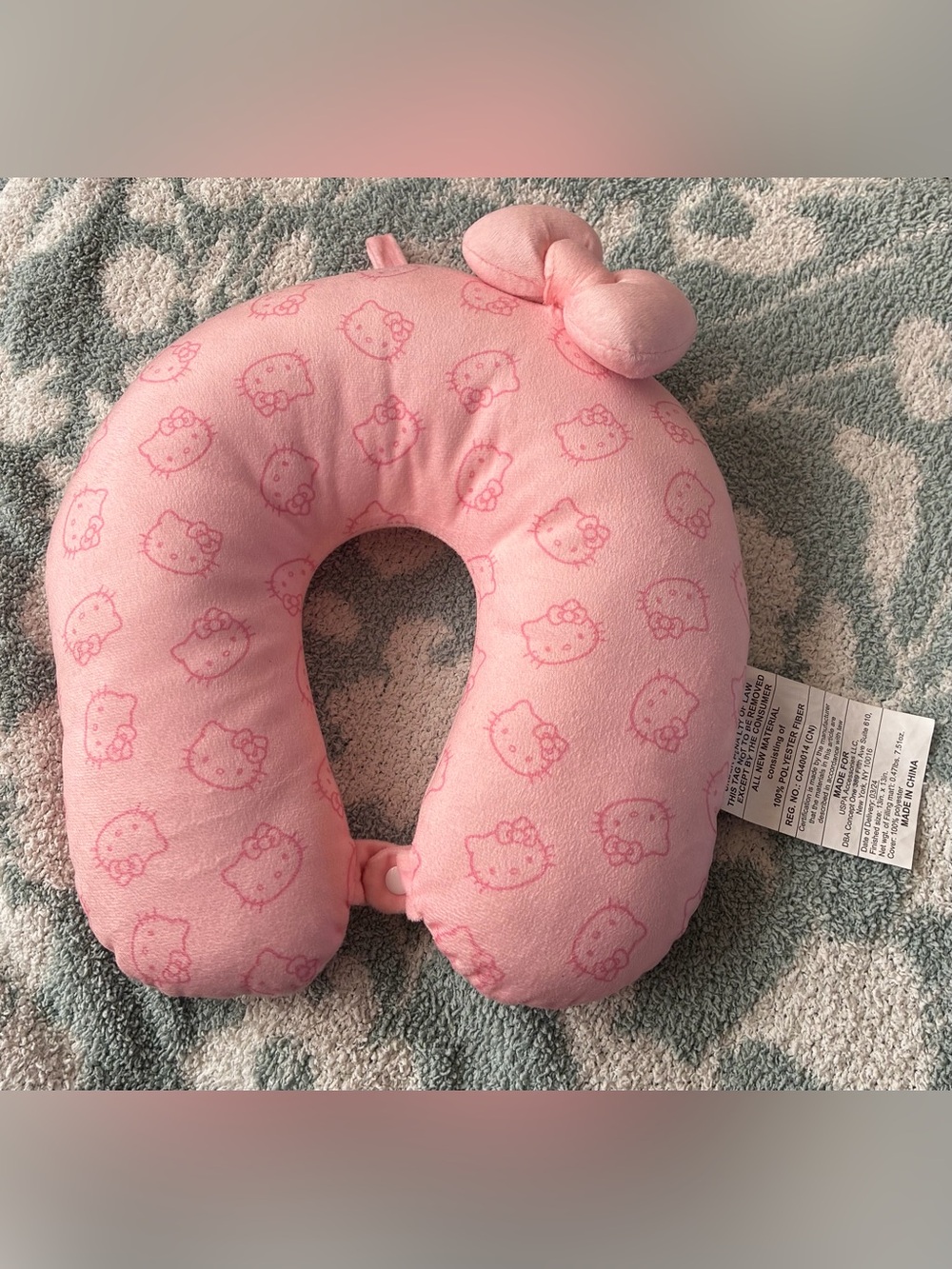Sanrio Hello Kitty pink neck pillow with repeating Hello Kitty faces